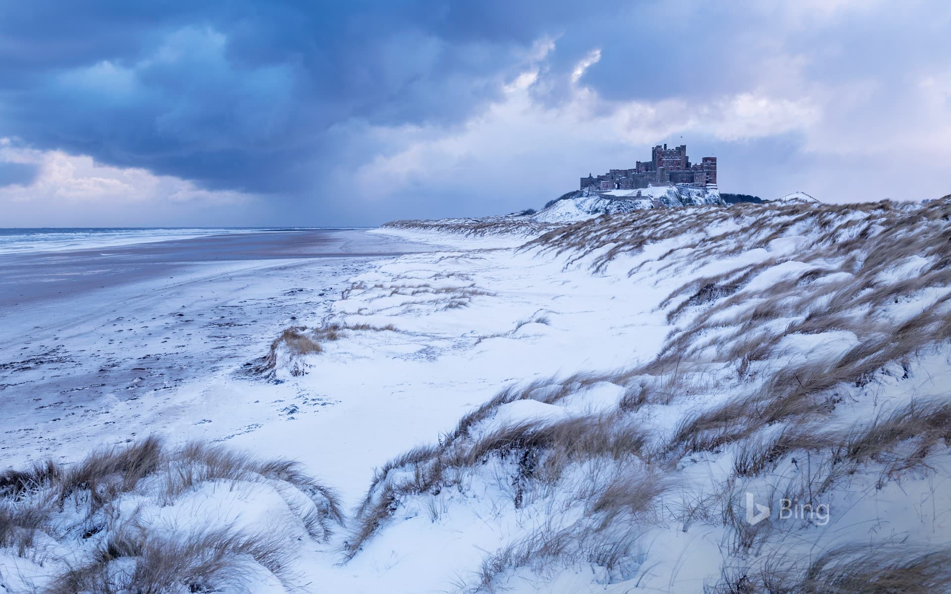 Bing Wallpaper: Bamburgh Castle and sand dunes after snowfall in Northumberland
