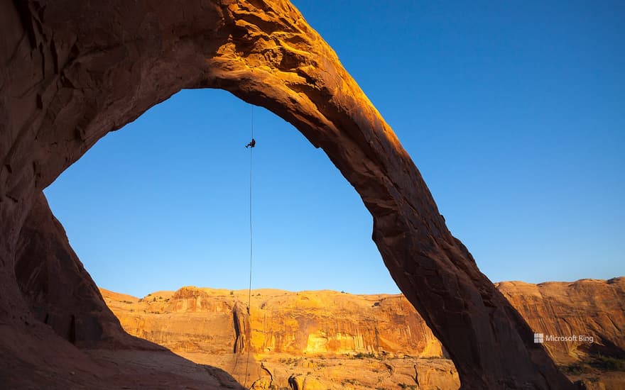 A man rappels off Corona Arch near Moab, Utah, United States