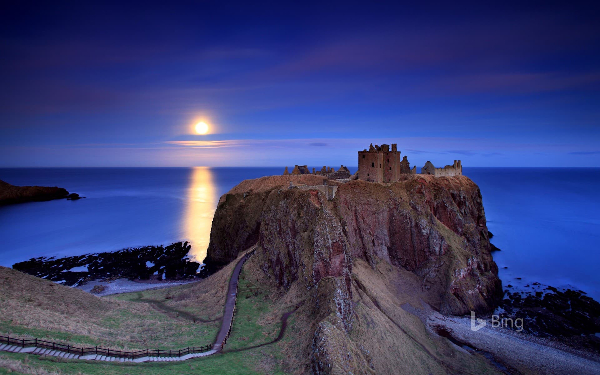 Bing Wallpaper: Full moon rising over Dunnottar Castle near Stonehaven on the northeast coast of Scotland