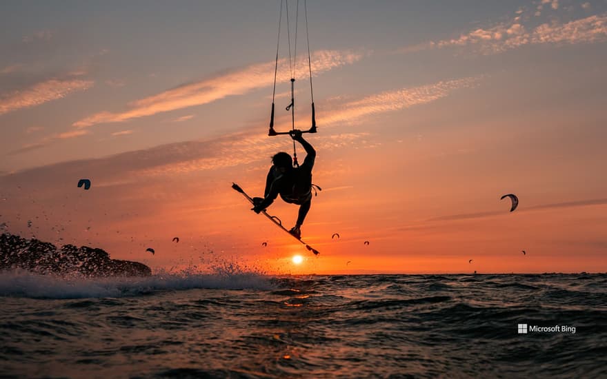 Silhouette of a jumping kitesurfer at sunset in the Baltic Sea