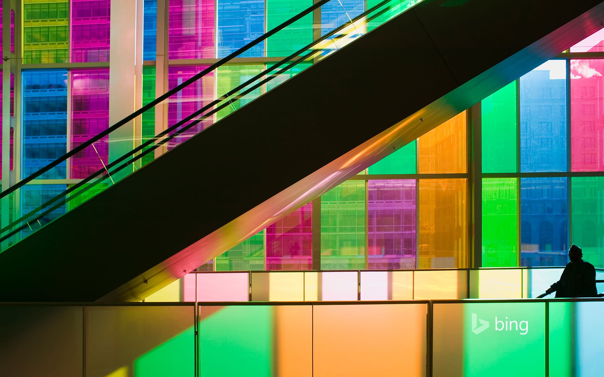 Bing Wallpaper: Silhouetted man standing in front of multi-coloured glass windows of Montreal's Palais des Congres Montreal, Quebec, Canada