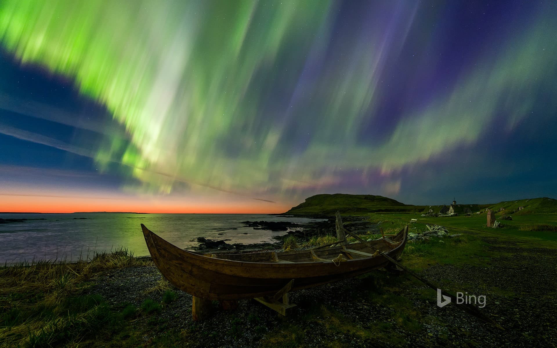 Bing Wallpaper: The northern lights over a rowboat in Norstead Viking Village, Newfoundland, Canada