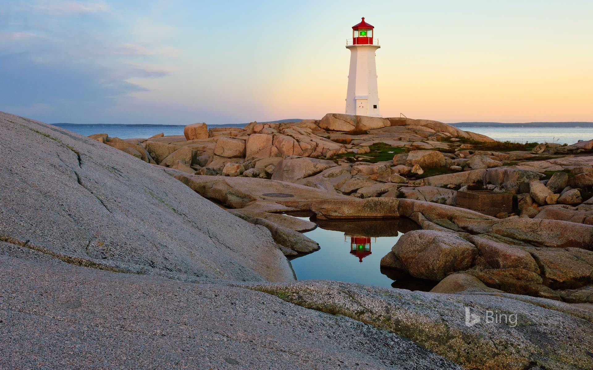Bing Wallpaper: Lighthouse reflected in a pool of water at Peggy's Cove, Nova Scotia, Canada