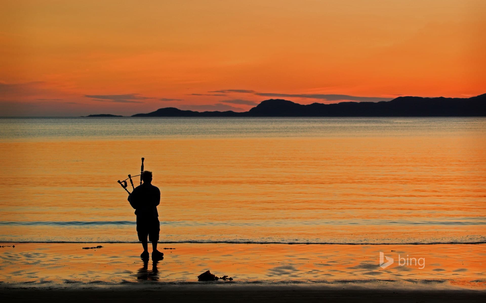 Bing Wallpaper: A bagpiper on Arisaig beach in Scotland
