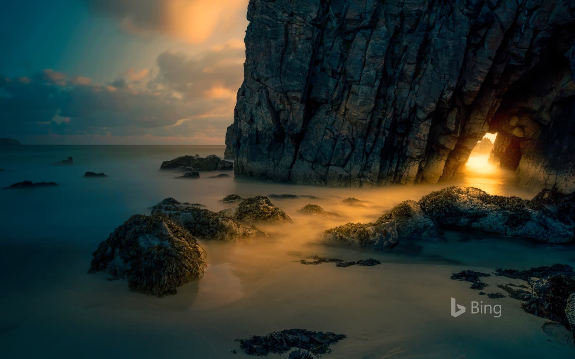 Bing Wallpaper: Light from sunrise through a sea cave on the Isle of Skye, Scotland