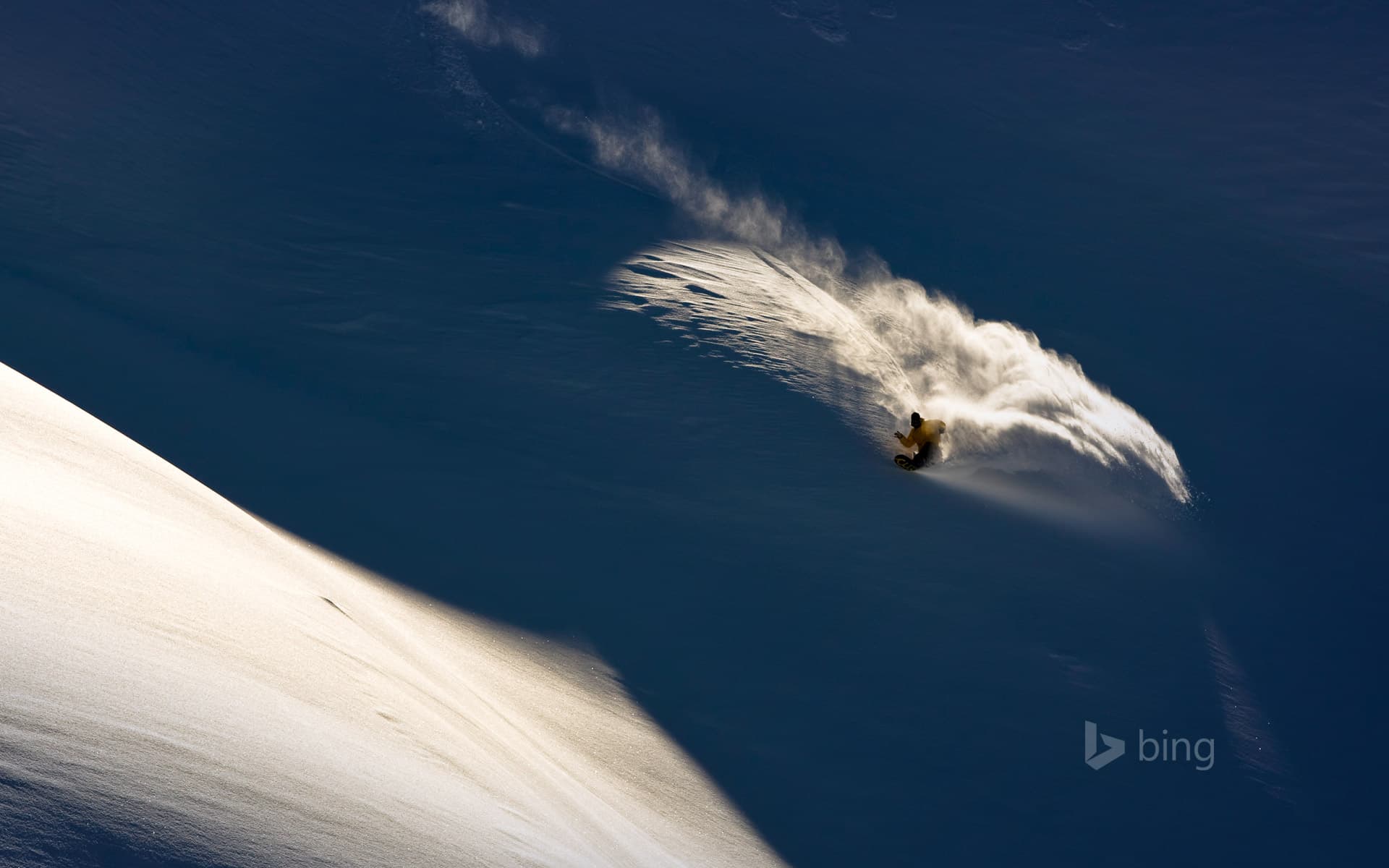 Bing Wallpaper: Snowboarder makes powder turn in backcountry terrain