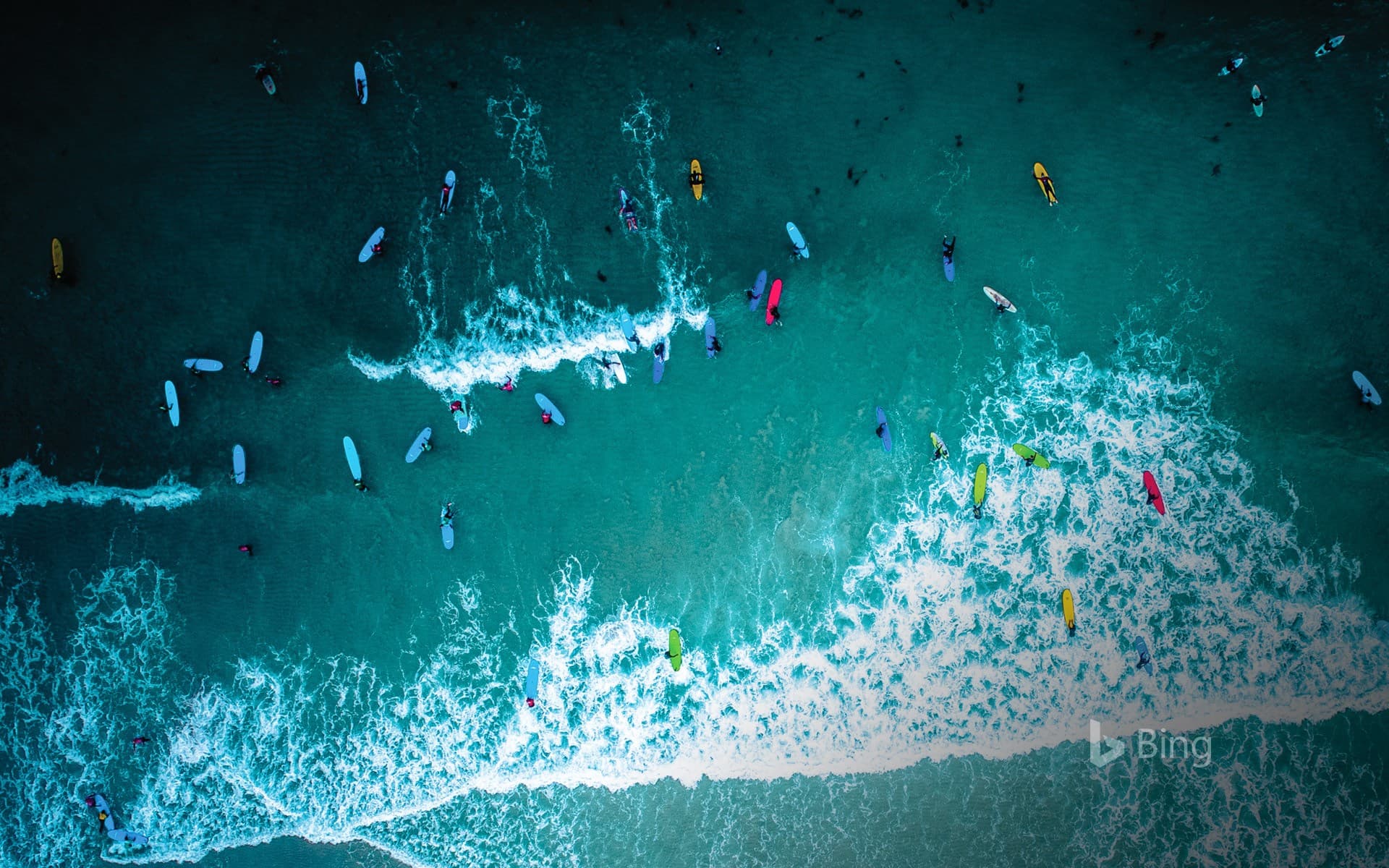 Bing Wallpaper: Aerial view of surfers in Cornwall for International Surfing Day