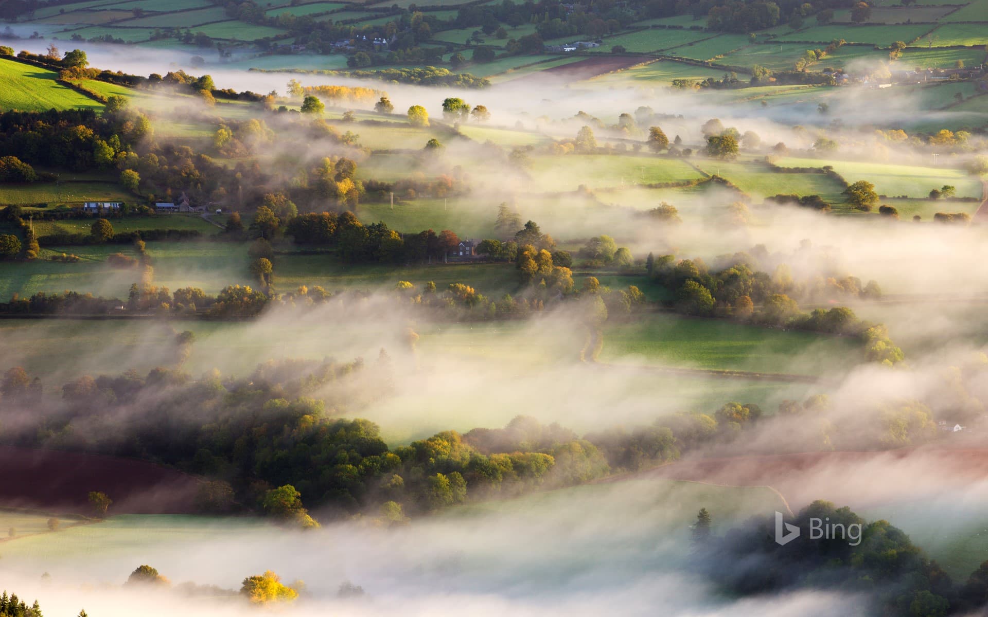 Bing Wallpaper: Mist blows over rolling countryside near Talybont-on-Usk in Brecon Beacons National Park, Wales