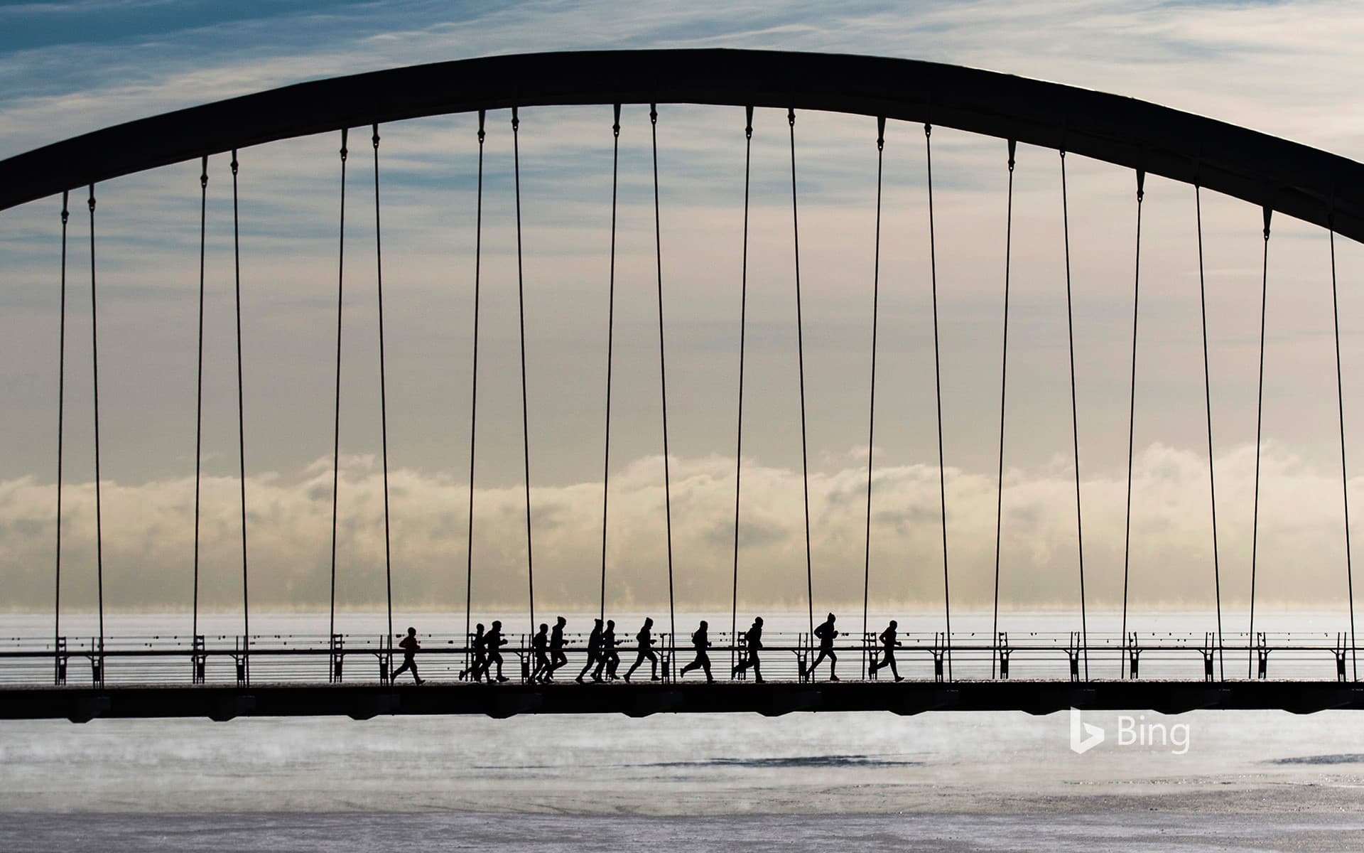 Bing Wallpaper: A group of joggers run across the Humber Bay Arch Bridge in Toronto, Canada